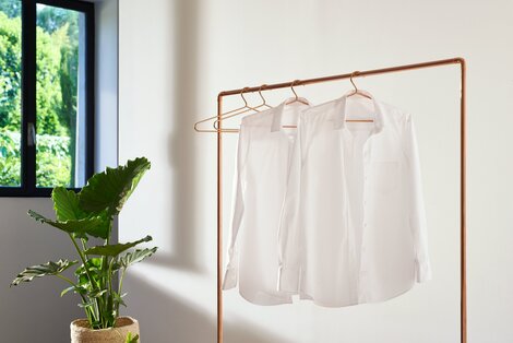 2.Börja med manschetterna genom att knäppa upp dem och lägga platt på strykbrädan.