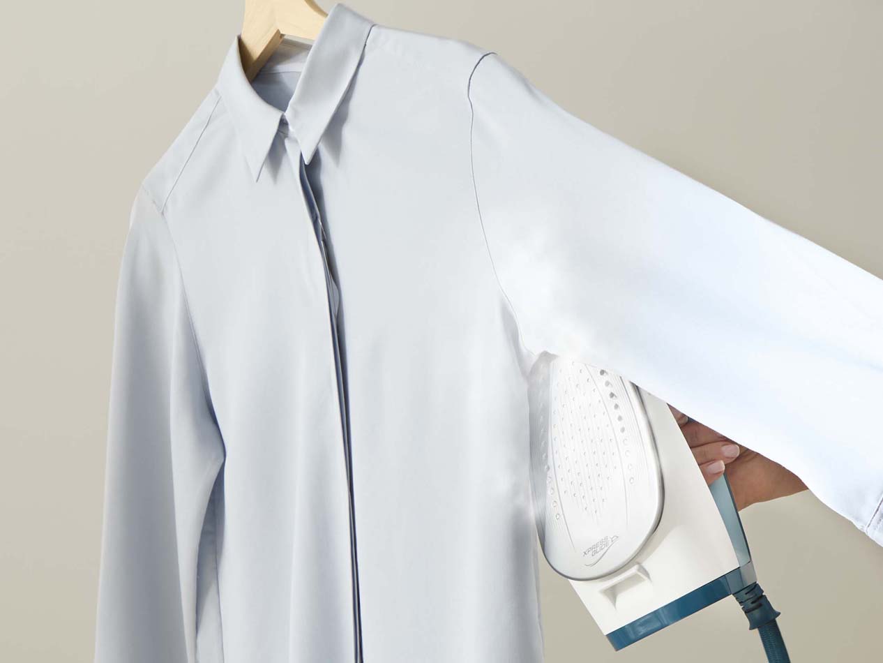 5. Lägg ärmarna platt och stryk från axeln nedåt för att undvika nya skrynklor.